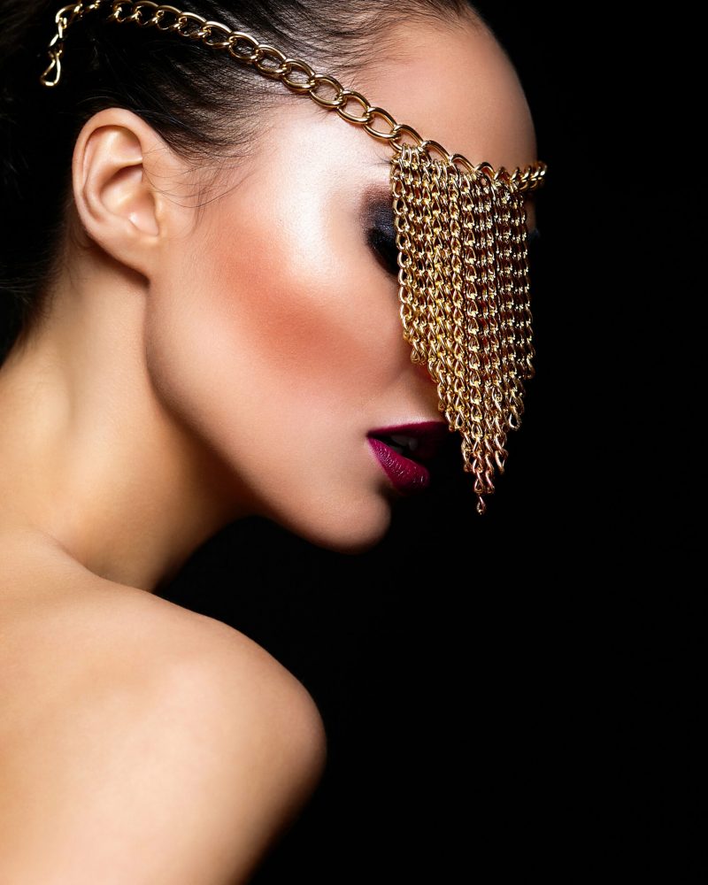 High fashion look.glamor closeup portrait of beautiful sexy Caucasian young woman model with colorful lips,bright makeup, with perfect clean skin with jewelery on eye isolated on black High fashion look.glamor closeup portrait of beautiful sexy Caucasian young woman model with colorful lips,bright makeup, with perfect clean skin with jewelery on eye isolated on black